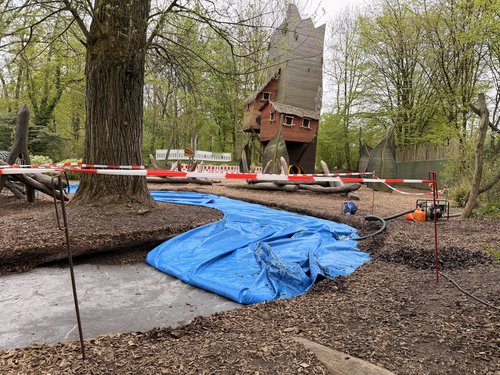 Spielplatz mit Absperrband und halbem blauen Wasserkissen
