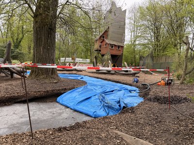 Spielplatz mit Absperrband und halbem blauen Wasserkissen