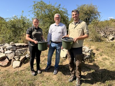 Drei Personen mit Eimern in der Hand